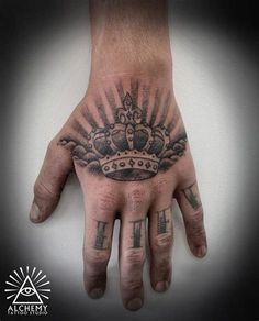 a man's hand with a crown tattoo on it