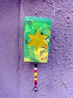 a green bag with a yellow star hanging from it's side on a purple wall