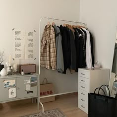 a closet with clothes hanging on the wall and a suitcase sitting on the floor next to it