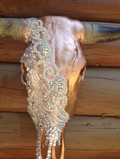 a cow's skull is adorned with beaded and sequins on the side of a wooden building