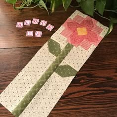 a piece of fabric next to a flower on a wooden table