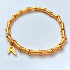 Bamboo Bracelet Gold 24K Plated Lucky Wealth Prosperity 🎋 Bracelet Approx. size: 6.5 🎋 Stretch Elastic Bracelet  🎋 Bamboo 24K Gold Plated Beads (7mm x 4mm) Each bead has a money coin symbol. 🎋 24K Gold Plated Spacer Beads and Bamboo Leaf Charm  📷 Check out our instagram @little.rainbow.factory for more pictures/videos of this item Photos were taken in natural sunlight. Please keep in mind that colors may vary from the photos taken due to the settings on your phone or monitor display and surface. *Please note that jewelry may tarnish due to oxidization* Adjustable Symbolic Gold Beaded Bracelets, Gold Bangle Stretch Bracelet, Symbolic Gold Bangle Bracelet, Flexible Yellow Gold Stretch Bracelet Gift, Flexible Yellow Gold Stretch Bracelet For Gift, Yellow Gold Stretch Bracelet Gift, Gold Hand-strung Name Bracelet Gift, Symbolic Gold Beaded Bracelets As Gift, Symbolic Gold Beaded Bracelets For Gifts