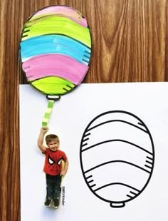 a paper cut out of a boy holding a balloon