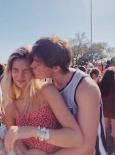 a man and woman hugging each other in front of an audience at a music festival