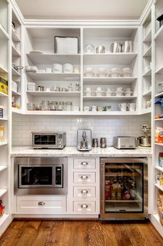 a kitchen with white cabinets and open shelving