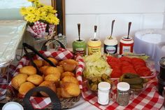 an assortment of food is displayed on a table with flowers and other items in the background