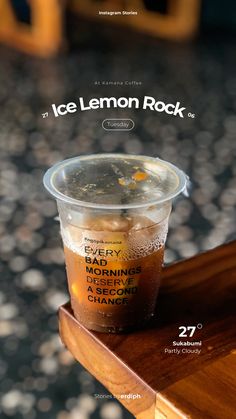 a cup of ice lemon rock tea sitting on top of a wooden table