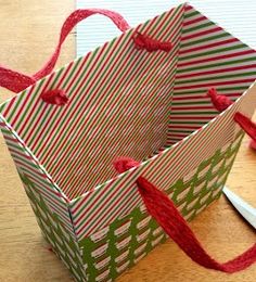 an origami shopping bag with red string tied around it on a wooden table