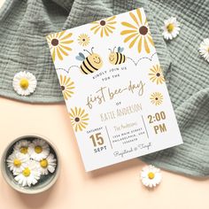 a yellow and white baby shower with daisies next to it on a pink background