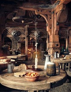 an old fashioned kitchen with wooden tables and stools in the center, surrounded by wine barrels