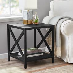 a black end table sitting on top of a wooden floor next to a white couch