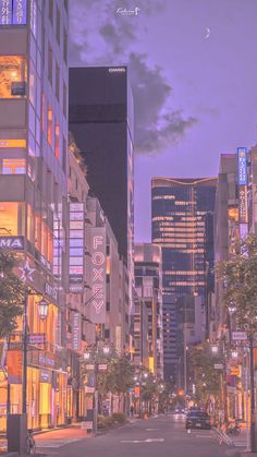 an empty city street at night with tall buildings