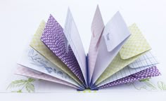 an origami book opened to show the pages folded in different colors and patterns