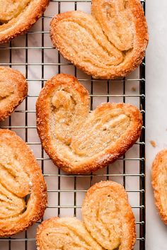 baked cookies cooling on a wire rack with powdered sugar in the shape of a heart