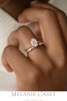 a woman's hand with a diamond ring on her finger and the text melanie casey fine jewelry