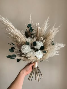 a hand holding a bouquet of white flowers