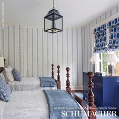 two beds in a bedroom with blue and white wallpaper