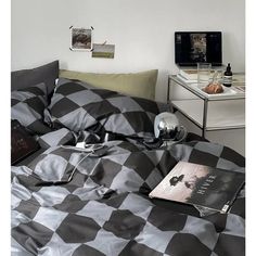 a black and white checkered bedspread with an open book on the bed