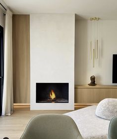 a living room with a fire place in the middle and a television mounted on the wall