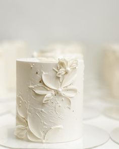 a close up of a white cake with flowers on the frosting and icing