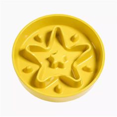 a yellow plastic bowl with an image of a star in the center and holes in the bottom