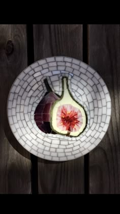 a white plate topped with sliced up fruit on top of a wooden table