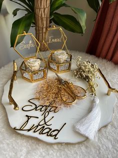 a table topped with cake and decorations on top of a white tray next to a potted plant