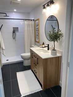 a bathroom with black and white tile flooring and wooden cabinetry, along with a plant on the counter