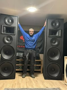 a man standing in front of two large speakers