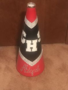 a red and black cone shaped object with the word h on it's side