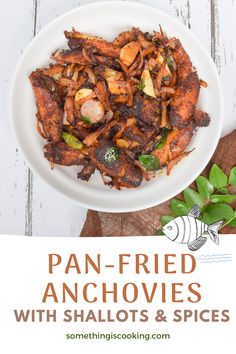 pan fried anchovies with shallots and spices in a white bowl on a wooden table