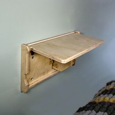 a wooden shelf mounted to the side of a wall