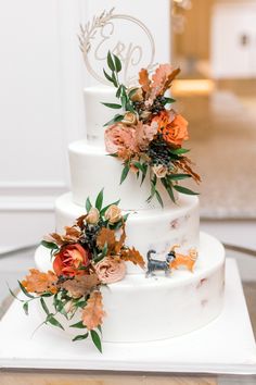 a three tiered wedding cake with flowers on top