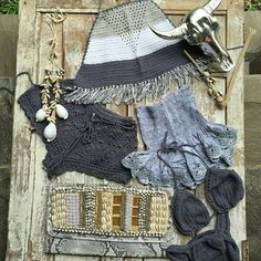 an assortment of knit and crochet items displayed on wooden planks in outdoor setting