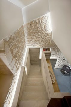 an aerial view of a staircase leading up to a room with stone walls and flooring