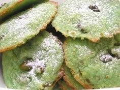 green cookies with powdered sugar on them in a white bowl