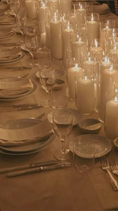 a long table is set with candles and place settings for formal dinner guests to enjoy