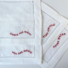 four embroidered napkins with words on them