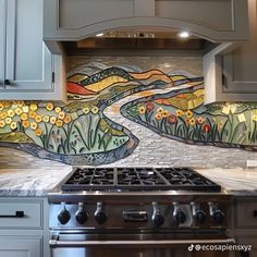 a stove top oven sitting under a painting on the side of a kitchen wall next to an oven