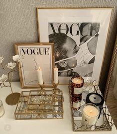 a table topped with candles and pictures next to a candle holder on top of a table