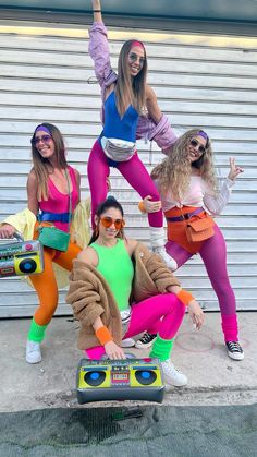 four women dressed in costumes posing for a photo with some boomboxs and speakers