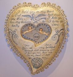 a heart shaped clock with two angels on it