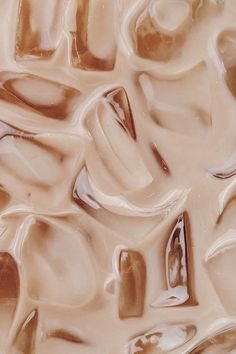 a close up view of some liquid in the shape of an abstract design with brown and white colors