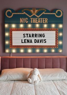 a teddy bear sitting on top of a bed in front of a sign that says staring lena davis