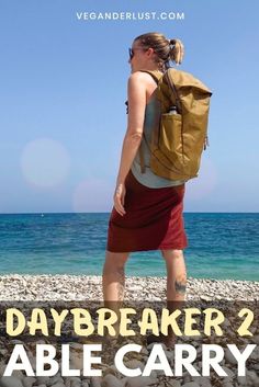 a woman standing on the beach with a backpack over her shoulder and text reading daybreaker 2 able carry