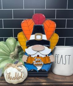 a thanksgiving decoration with a turkey, pumpkins and a coffee mug on a shelf