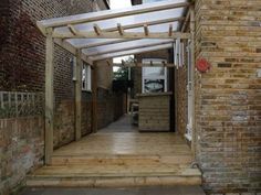 a wooden walkway leading to a brick building with an awning over the entrance area