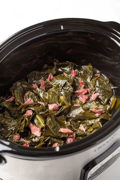 cooked collard greens in the crock pot ready to be put into the slow cooker