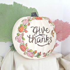 a white pumpkin with the words give thanks painted on it