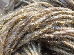 a close up view of some brown and white yarn with gold flecks on it